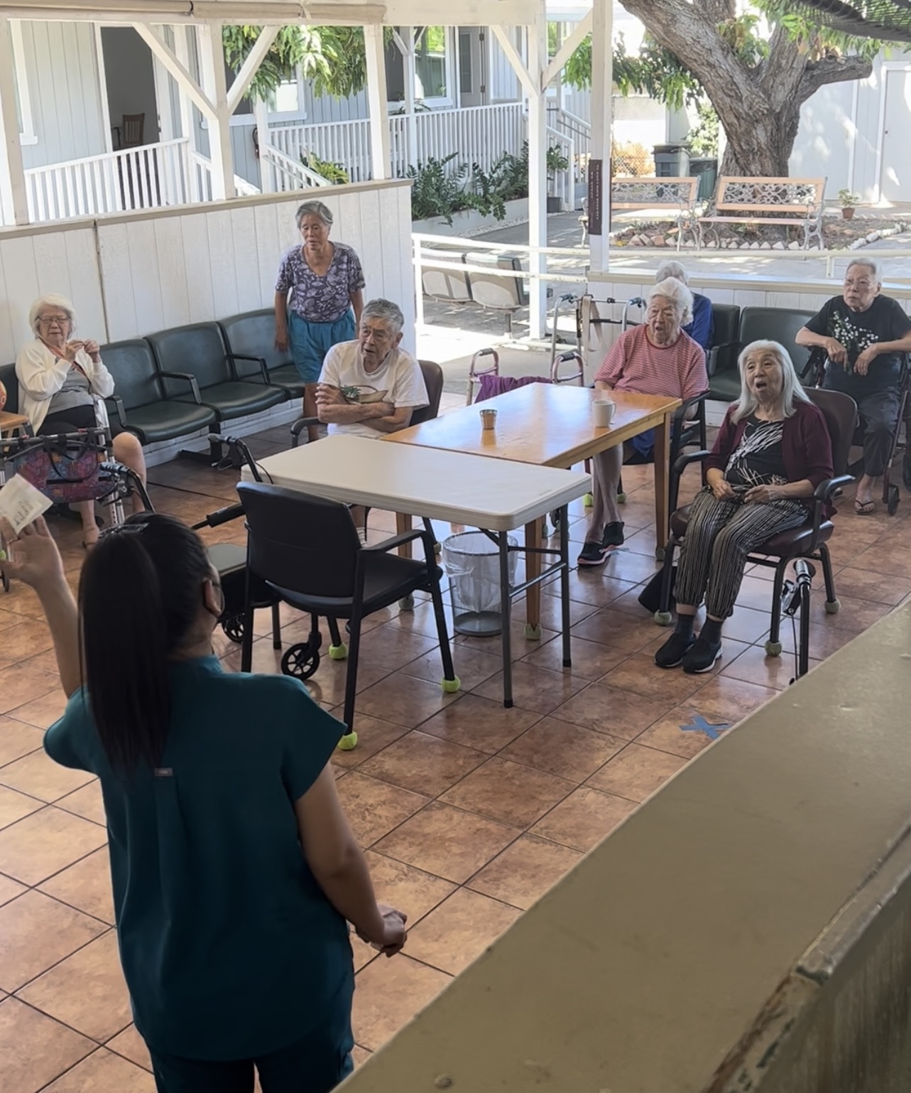 Activity coordinator leading group exercise on the covered patio